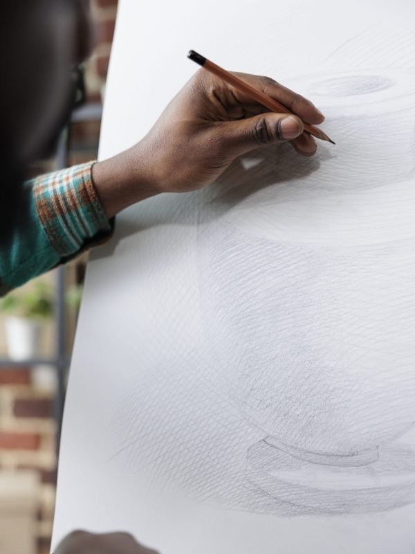 Close up of african american student hand sketching vase model on canvas Close up of african american student hand sketching vase model on canvas learning new sketch skill during art class in educational school studio. Artist man drawing illustration using graphic pencil